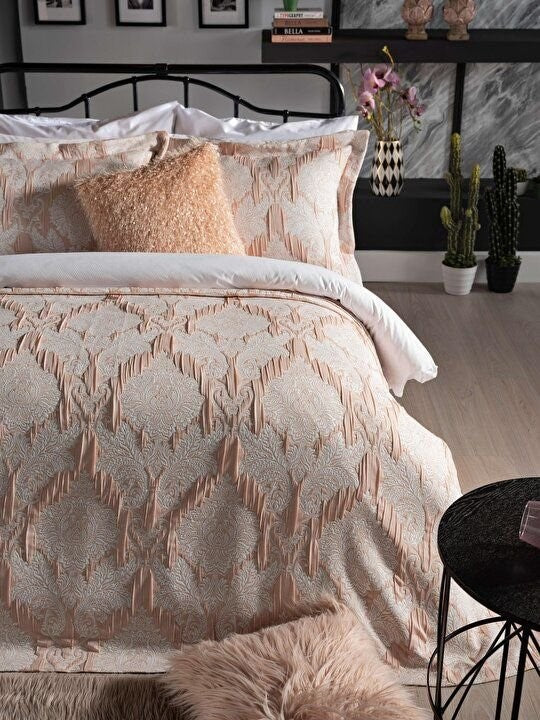 Light pink bedspread set in king size, including a bed cover and two pillowcases.