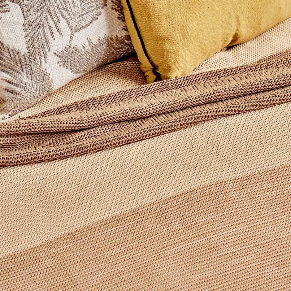 Beige bed blanket with soft and cozy texture in queen size.